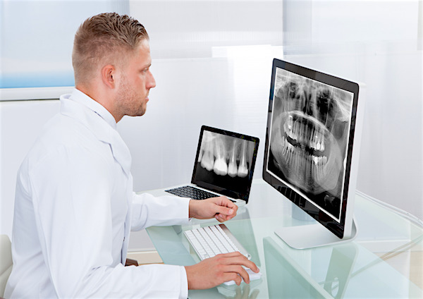 Doctor-radiologist-x-ray online-desktop monitor as he makes a diagnosis or checks prognosis