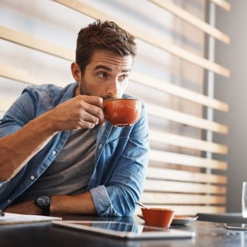 Un homme boit une tasse de café